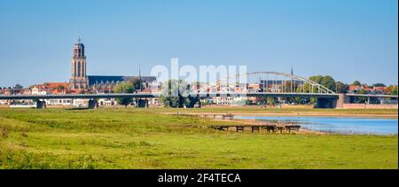 Holländisches Panorama landschape in der Nähe der Hanze Stadt Deventer. Die berühmte Wilhelmina-Brücke und die große Kirche oder die St. Lebuinus-Kirche sind ebenfalls zu sehen Stockfoto