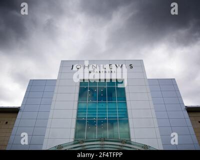 Der Eingang zum John Lewis & Partners Store unter dunklen Wolken im Mall Shopping Centre, Cribbs Causeway, Gloucestershire in der Nähe von Bristol, England. Stockfoto