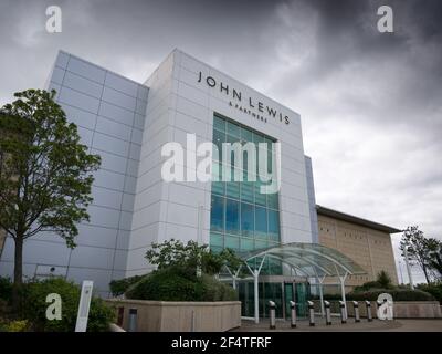 Der Eingang zum John Lewis & Partners Store unter dunklen Wolken im Mall Shopping Centre, Cribbs Causeway, Gloucestershire in der Nähe von Bristol, England. Stockfoto