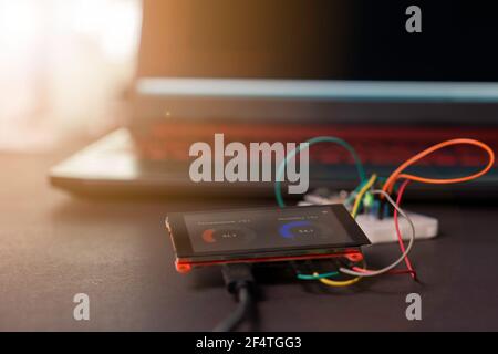 Mit dem Notebook-Computer Programm auf den Mikrocontroller hochladen LCD-Monitor und das Experimentierboard, um das IoT zu studieren Projekt „Internet der Dinge“ Stockfoto