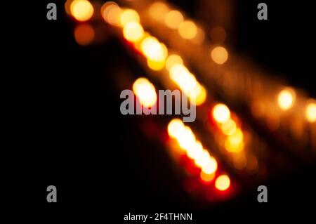 Verschwommenes Foto von Kerzen im dunklen Tempel. Bokeh. Hintergrund des Memorial Light. Gebet für kranke Geliebte. Gebet für kranke Personen Konzept. Stockfoto