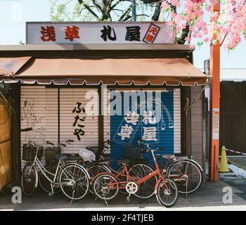 Asakusa, Tokyo, Japan - Fahrräder vor dem geschlossenen Geschäft in der Nähe von Senso-ji geparkt. Stockfoto