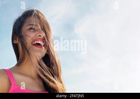 EINE GLÜCKLICHE JUNGE FRAU, DIE DRAUSSEN LACHT Stockfoto