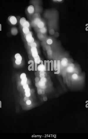 Verschwommenes Foto von Kerzen im dunklen Tempel. Bokeh. Hintergrund des Memorial Light. Gebet für kranke Geliebte. Gebet für kranke Personen Konzept. Schwarz-weiß-phot Stockfoto