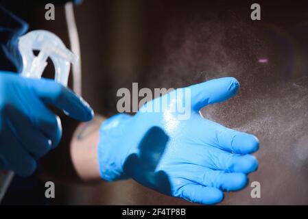 Tatto Salon Nahaufnahme. Ein Mann mit Schutzhandschuhen desinfiziert seine Hände vor der Arbeit. Stockfoto