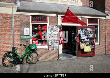 AMSTERDAM, NIEDERLANDE-MÄRZ 9: Grünes Heineken Fahrrad vor dem Souvenir Shop geparkt. März 9,2014 in Amsterdam, Niederlande. Stockfoto