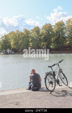 Schöner Hiroshima-Nagasaki Park im Frühjahr, Blick auf den See mit einem Mann ein Fahrrad, Köln, Deutschland Stockfoto