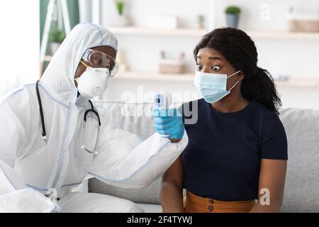 Schockiert afroamerikanische Frau Patientin Blick auf Thermometer Bildschirm Stockfoto