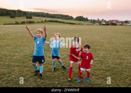 Kinder spielen Amateurfußball. Fröhliche Jungen in Fußballkleider, die Spaß beim Training auf dem Spielfeld haben. Stockfoto