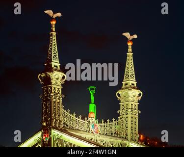 Einzigartige Aussicht auf die berühmte historische Freiheitsbrücke und Statue in Budapest Ungarn. Dekoriert mit grünen Lichtern am St. Patrick Memorial Day. Stockfoto