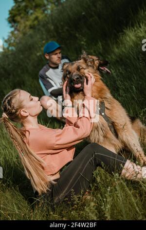 Aktive Familie, Fitness-Paar, Pet Love, Dog Training, beste Hunderassen für die Familie. Junge Sport Paar zu Fuß mit zwei Schäferhunde im Freien Stockfoto