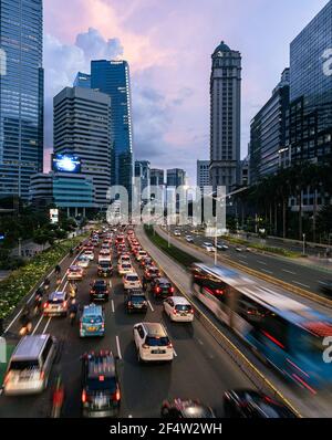 Jakarta, Indonesien - März 22 2021: Der Verkehr, der von unscharfen Bewegungen erfasst wurde, rast entlang der Sudriman Straße im Geschäftsviertel in Indonesien capi Stockfoto