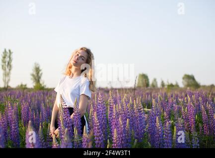 Ruhe in der Natur . Schöne traurige Teenager Mädchen unter lila Wildblumen auf der Wiese. Schöner warmer Sommertag Stockfoto