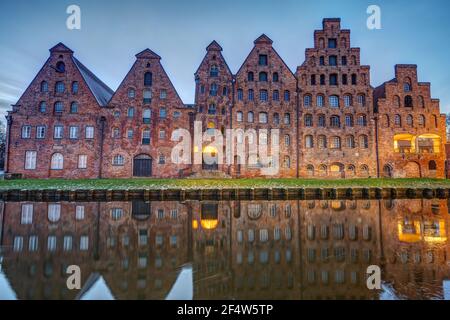 Der alte Salzspeicher, der in der Trave bei Sonnenaufgang reflektiert, gesehen in Lübeck, Deutschland Stockfoto