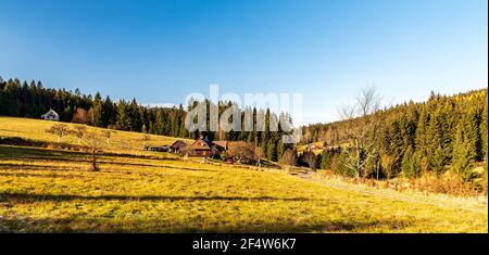Herbst hügelige Landschaft mit Wiese, wenigen isolierten Häusern, Wald und klaren Himmel - Vysni Mohelnice unten Lysa hora Hügel in Moravskoslezske Beskydy mou Stockfoto