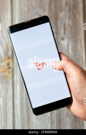 Ein Mobiltelefon oder Mobiltelefon, das in einem gehalten wird Hand mit der Tango App geöffnet auf dem Bildschirm Stockfoto