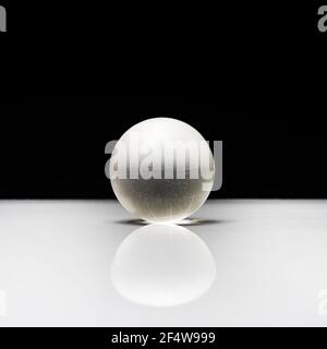 Eine Glaskugel auf einer weißen Oberfläche Stockfoto