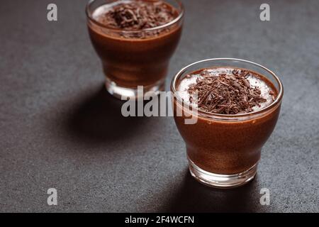 Hausgemachte dunkle Schokolade Mousse in Gläsern auf dunkelgrauen Tisch, Nahaufnahme Stockfoto