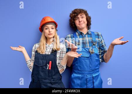 Bauingenieure Missverständnis, zucken und Blick auf Kamera awearing Uniform und Hardhats, arbeiten in der industriellen Fabrik. Engineering und Architektur Stockfoto