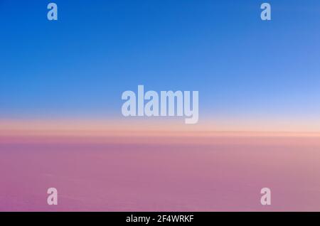 Schöne rosa Wolken bei Sonnenuntergang und blauen Himmel. Blick aus dem Flugzeug Stockfoto