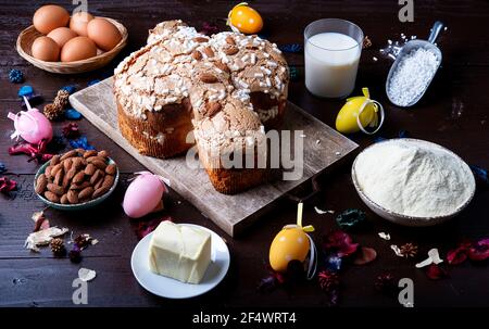 italienische ostertaubenkuchen (Colomba pasquale) Und Zutaten Milch Mandeleier auf alten rustikalen Holzbrett Stockfoto