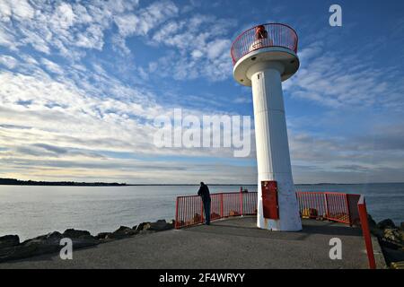 Sonnenuntergangslandschaft mit Panoramablick auf den Howth Harbour Lighthouse, ein historisches Wahrzeichen am nördlichen Ende der Dublin Bay in der Grafschaft Leinster, Irland. Stockfoto