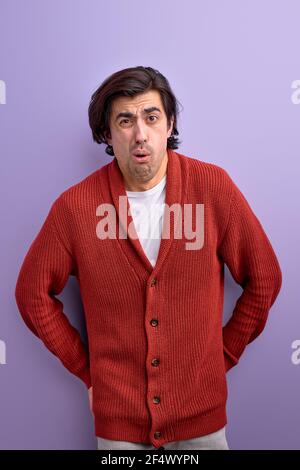 Schockiert Mann reagiert auf etwas unglaubliches, isoliert auf lila Hintergrund, Porträt von Brünette männlich in rot Casual Wear posiert Stockfoto