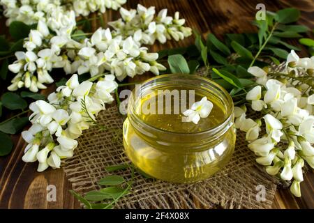 Honig und Akazienblumen auf dem rustikalen Holzhintergrund Stockfoto