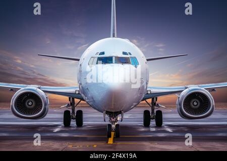 Verkehrsflugzeug auf einem Flugplatz gegen einen Sonnenuntergang Stockfoto