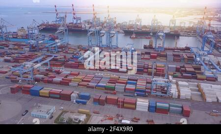 Draufsicht auf einen Hafen mit Ankerschiffen, Kräne und Frachtcontainern. Stockfoto