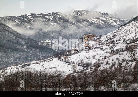 Verschneite Landschaft der Abruzzen Berge mit einem alten Dorf thront. Bisegna, Provinz L'Aquila, Abruzzen, Italien, Europa Stockfoto