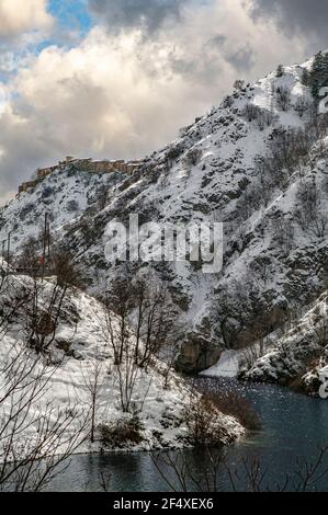 Winterlandschaft mit Dorf auf dem Berg und See thront. Villalago, Provinz L'Aquila, Abruzzen, Italien, Europa Stockfoto