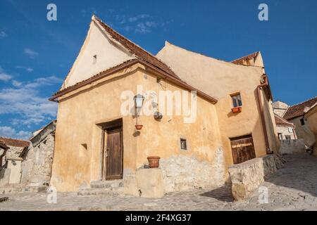 Innenhof und alte Häuser der Zitadelle Rasnov, kleine mittelalterliche Festung im traditionellen rumänischen Stil in der Nähe der Stadt Brasov. Traditionelles mittelalterliches Haus in Siebenbürgen Region von Rumänien. Stockfoto