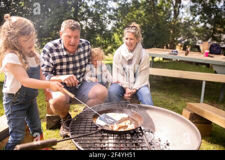 Fröhliche Familie Grillen auf sonnigen Campingplatz Stockfoto