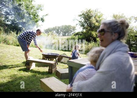 Familie genießt Grill im sonnigen Sommerhof Stockfoto