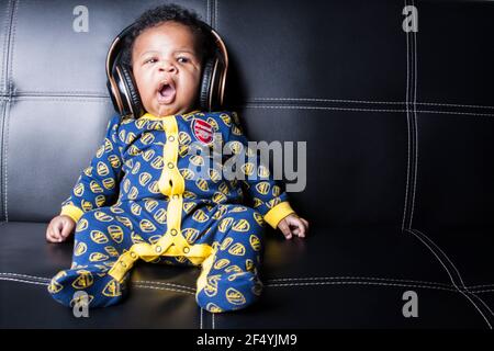 Niedlicher Junge in einem Arsenal Baby-Grow Stockfoto