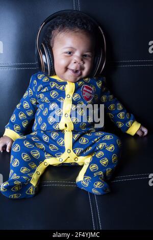 Niedlicher Junge in einem Arsenal Baby-Grow Stockfoto