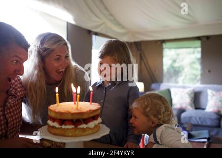 Happy girl feiert Geburtstag mit Familie und Erdbeerkuchen Stockfoto