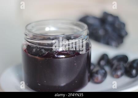 Hausgemachte Traubenmarmelade mit drei Zutaten, kernlosen schwarzen Trauben, Zucker und Limettensaft. Aufnahme auf weißem Hintergrund Stockfoto