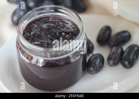 Hausgemachte Traubenmarmelade mit drei Zutaten, kernlosen schwarzen Trauben, Zucker und Limettensaft. Aufnahme auf weißem Hintergrund Stockfoto