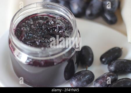 Hausgemachte Traubenmarmelade mit drei Zutaten, kernlosen schwarzen Trauben, Zucker und Limettensaft. Aufnahme auf weißem Hintergrund Stockfoto