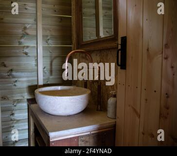 Waschbecken und Kupferhahn in der Kabine Badezimmer Stockfoto