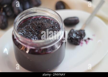 Hausgemachte Traubenmarmelade mit drei Zutaten, kernlosen schwarzen Trauben, Zucker und Limettensaft. Aufnahme auf weißem Hintergrund Stockfoto
