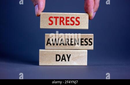 Symbol für den Tag des Stressbewusstseins. Holzblöcke mit den Worten "Stress Awareness Day". Schöner grauer Hintergrund. Arztzand. Psychologisch, geschäftlich und stre Stockfoto