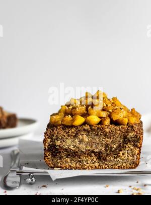 Frisch gebackenes, leckeres, warmes Zimt-Bananenbrot mit Zimt-Wirbel und karamalisierten warmen Äpfeln auf der Oberseite mit etwas Ahornsirup. Stockfoto