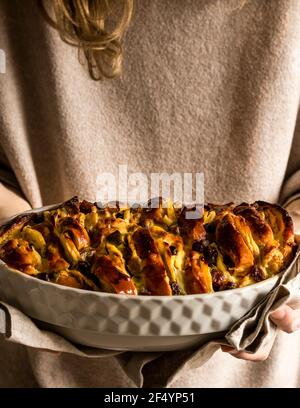 Frisch zubereitet, aus dem Ofen genommen vegane Brioche, Pudding und Apfelpudding mit Rosinen und getrockneten Aprikosen. Stockfoto