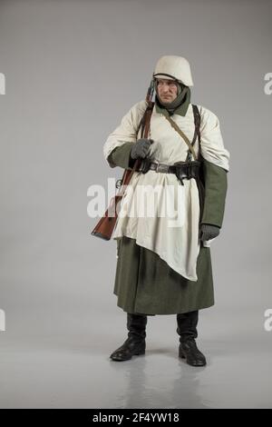 Männlicher Schauspieler in der Winteruniform eines deutschen Soldaten, der Periode 1942, dem Zweiten Weltkrieg, posiert auf grauem Hintergrund Stockfoto