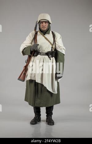 Männlicher Schauspieler in der Winteruniform eines deutschen Soldaten, der Periode 1942, dem Zweiten Weltkrieg, posiert auf grauem Hintergrund Stockfoto