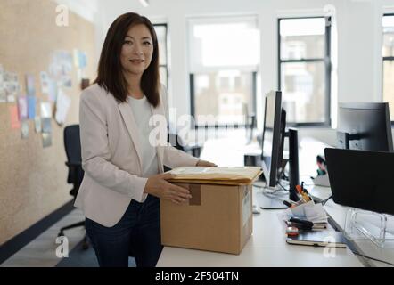 Portrait lächelnde Geschäftsfrau Empfang Pakete im Büro Stockfoto