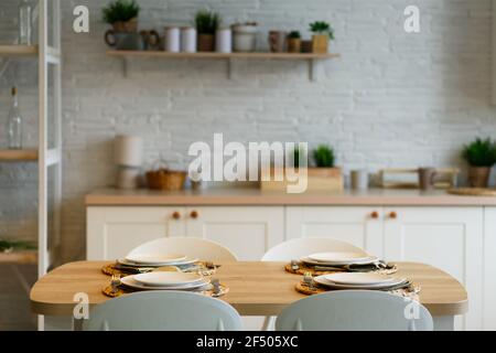 Weiße Platten mit Edelstahl Löffel und Gabeln auf der Platte Matten auf Holztisch. Stockfoto